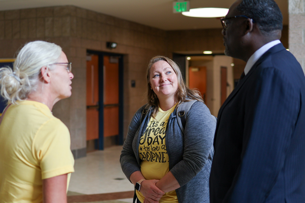 two women smile at a man