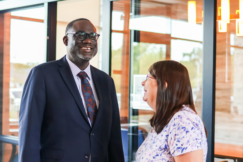 a man and woman smiling together in a conference room