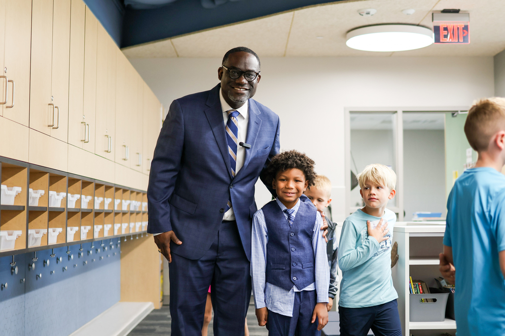 a man poses for a photo with a student wearing the same outfit