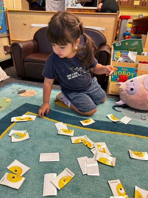 little girl playing a matching game on the floor.