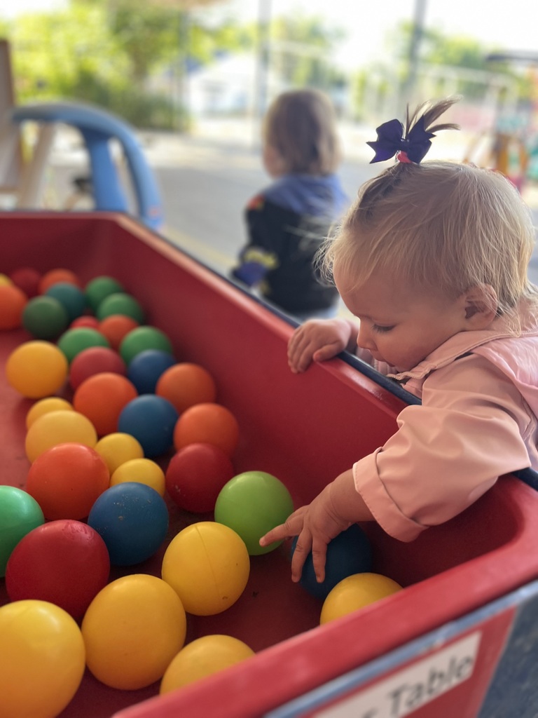 Little girl playing with balls.