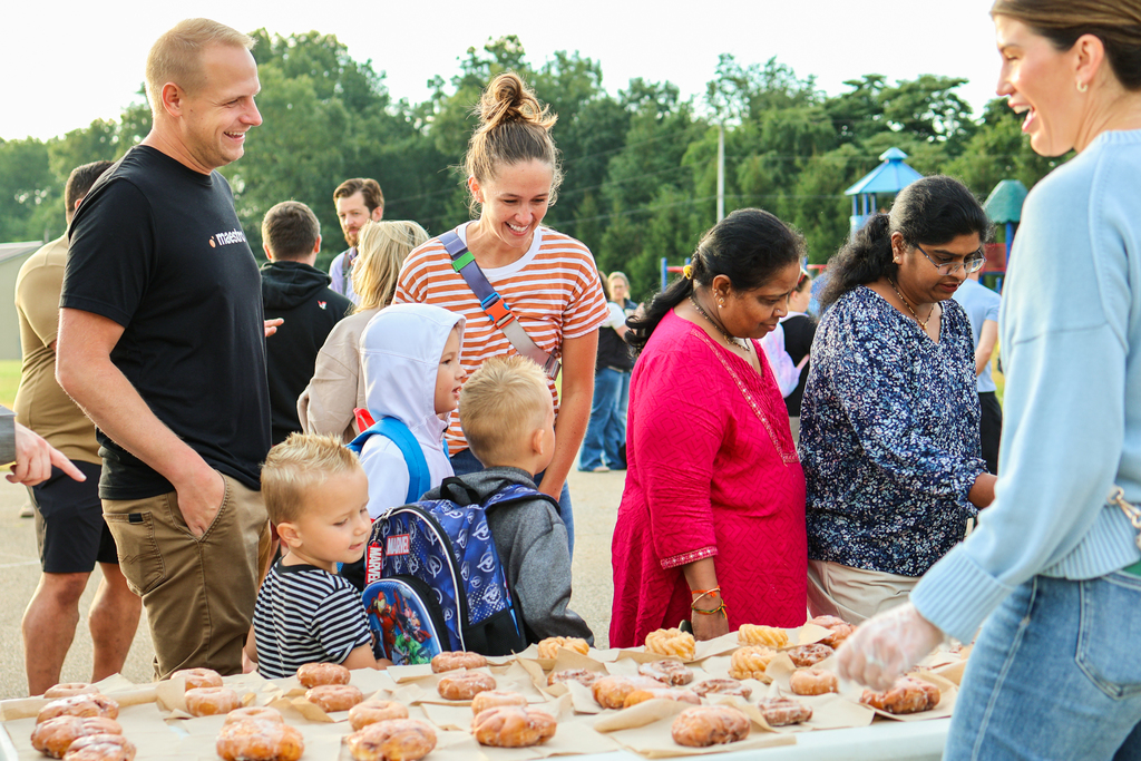 a family looking at donuts on a table