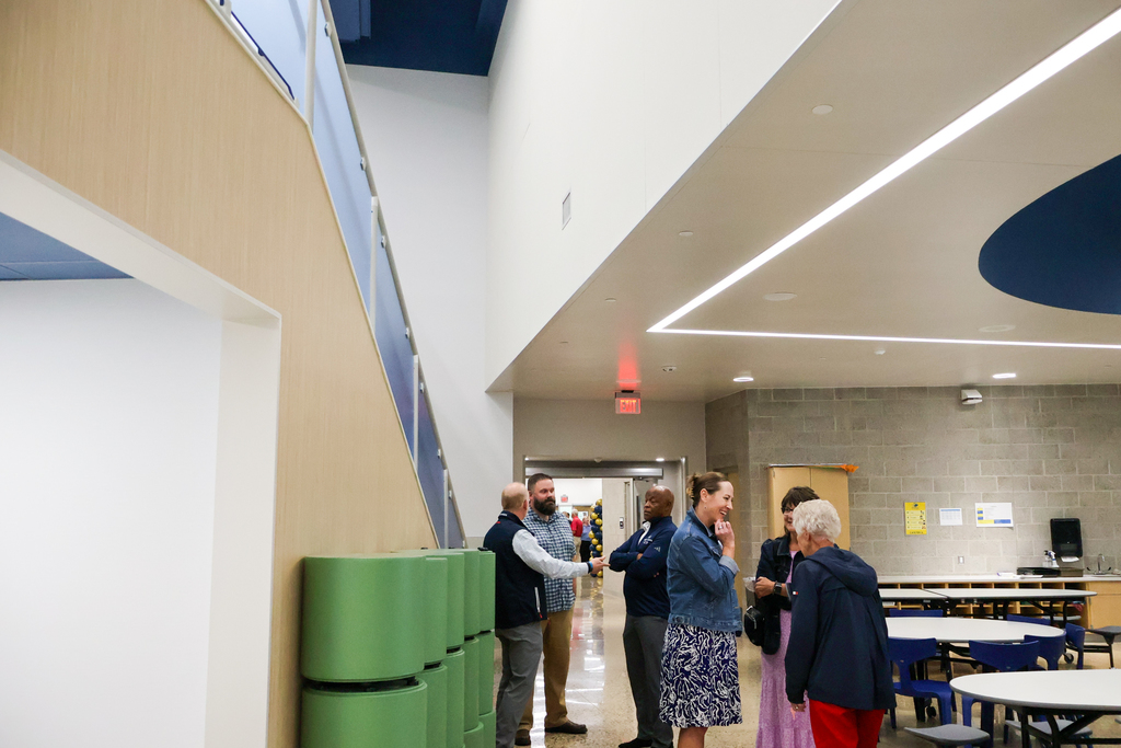 people standing and talking inside a school cafeteria