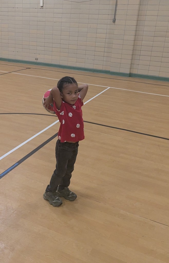 A boy playing with a basketball.