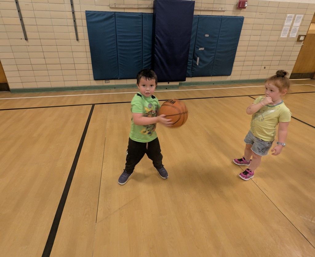 Two kids playing with a basketball.