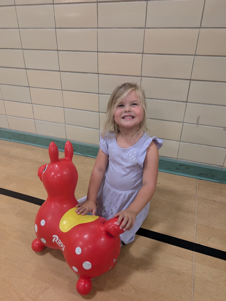 A girl playing with a pretend horse.