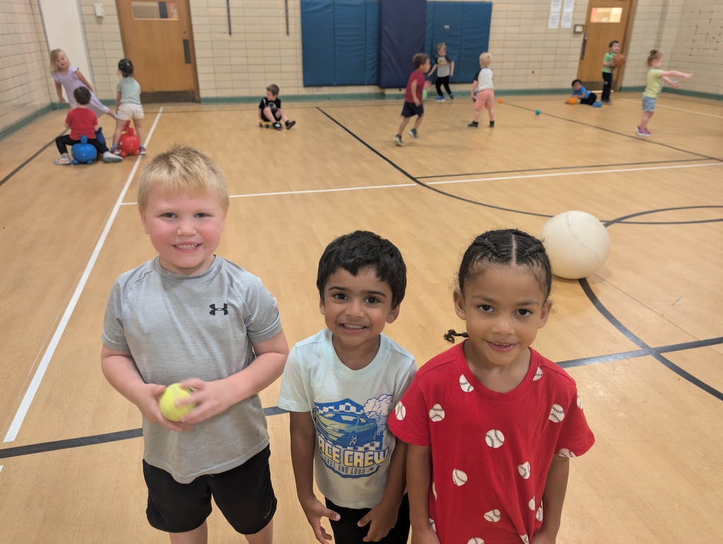 Three boys playing with a yellow ball.