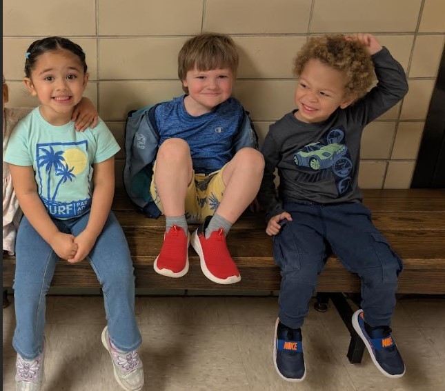 kids sitting on a bench together.