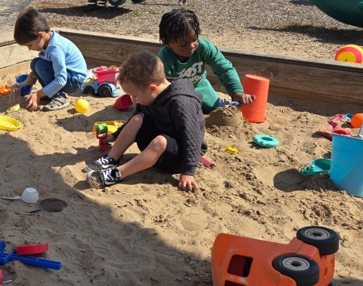 Three year olds in the sandbox together.