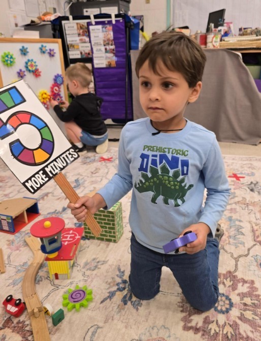 Boy student holding a sign at the carpet.