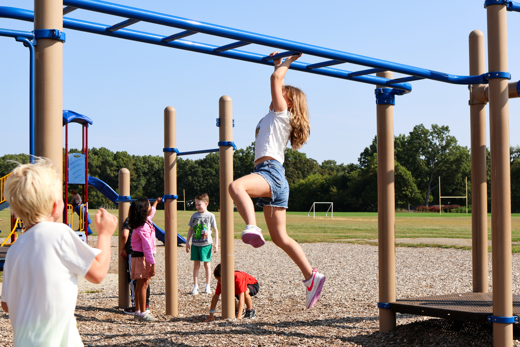 a girl crossing the monkey bars