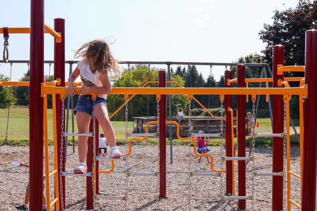 a girl climbing on playground equipment