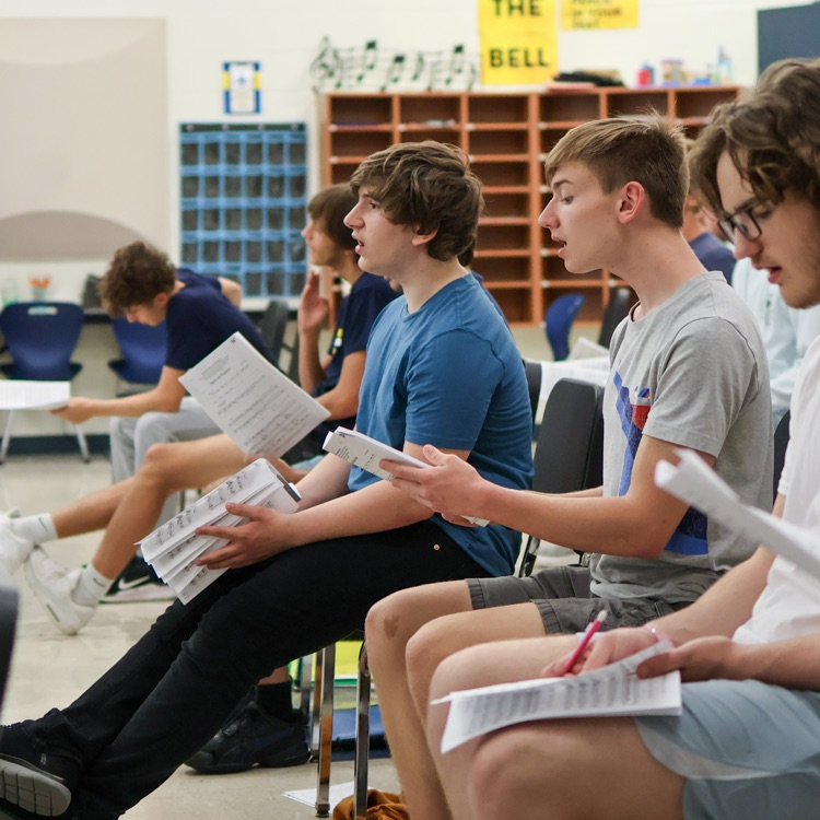 boys sitting in a choir room 