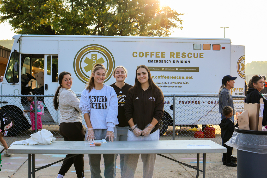 a handful of women pose for a photo in front of a coffee truck