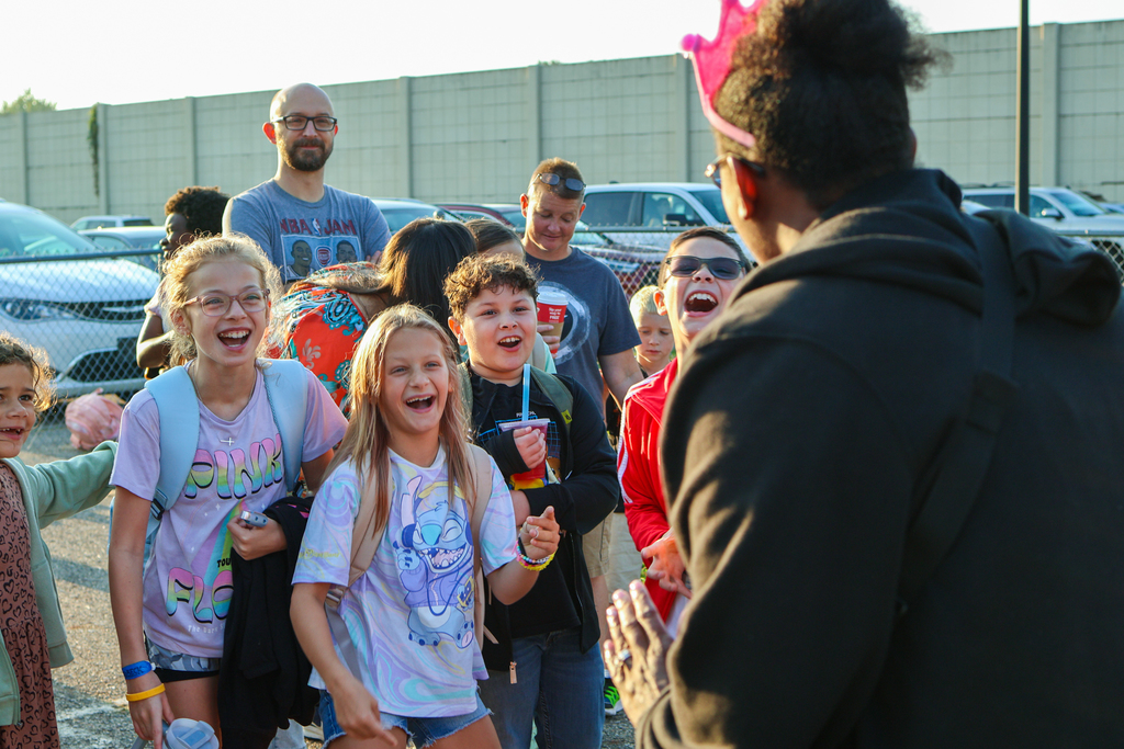 students laughing outside a school at an adult