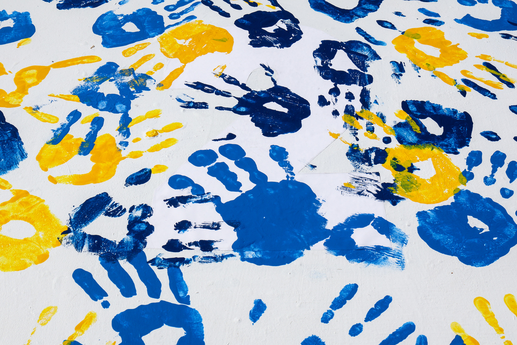 blue and yellow handprints on a white panel