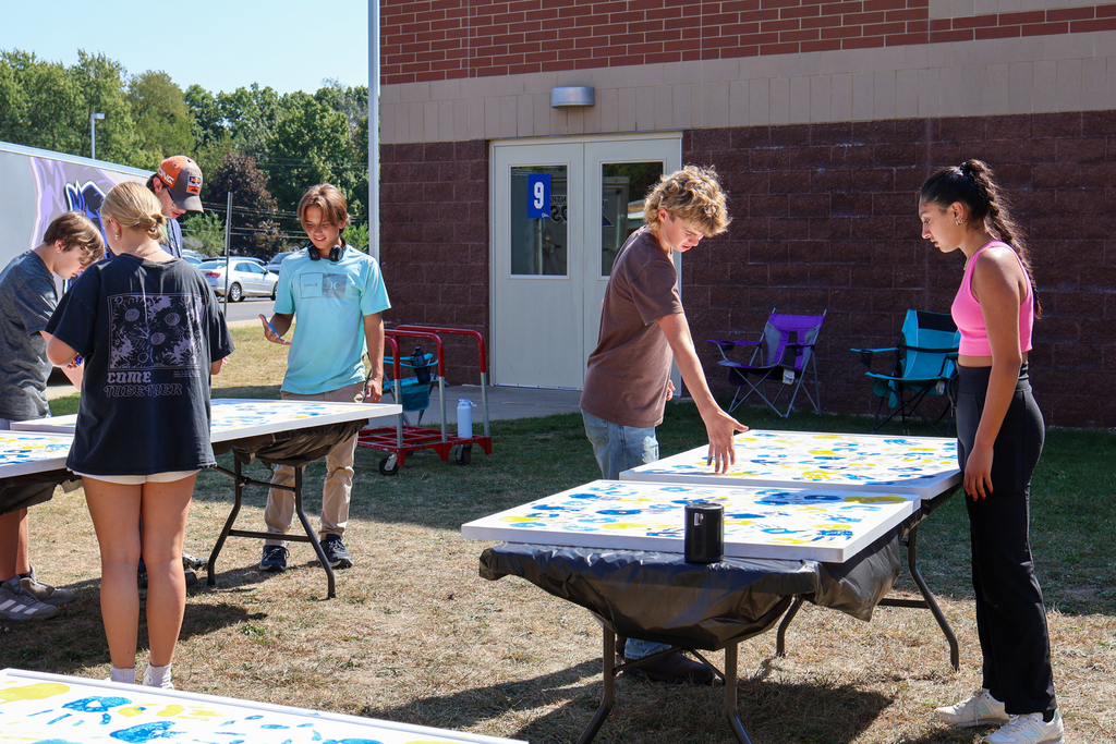 students put their handprint on panels outside a school