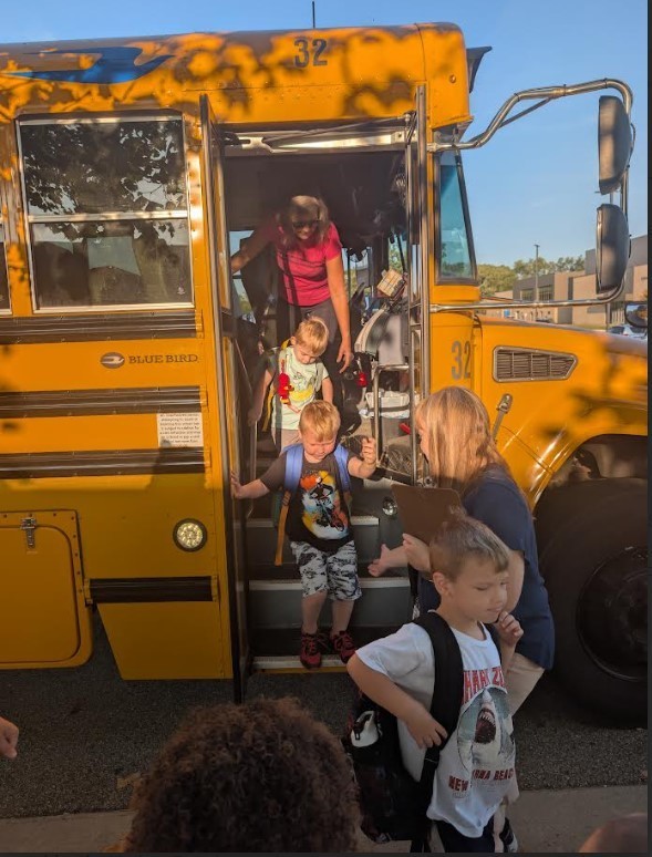 More students getting off the bus together. 