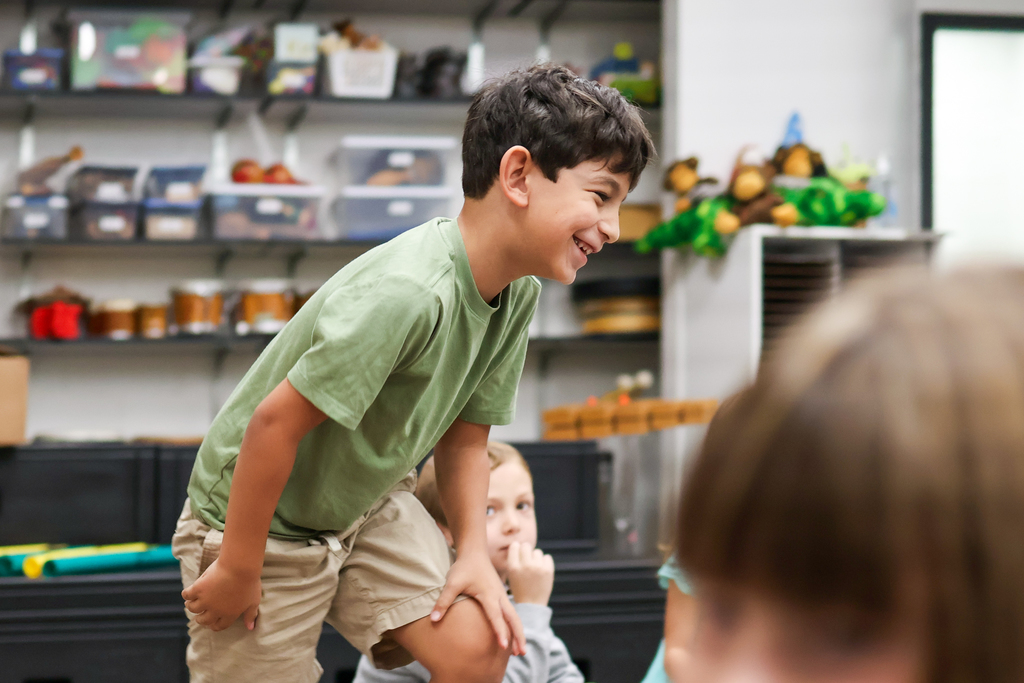 a boy smiles as he gets up off the floor