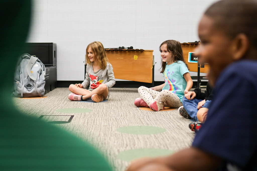 students sitting on the floor of a classroom