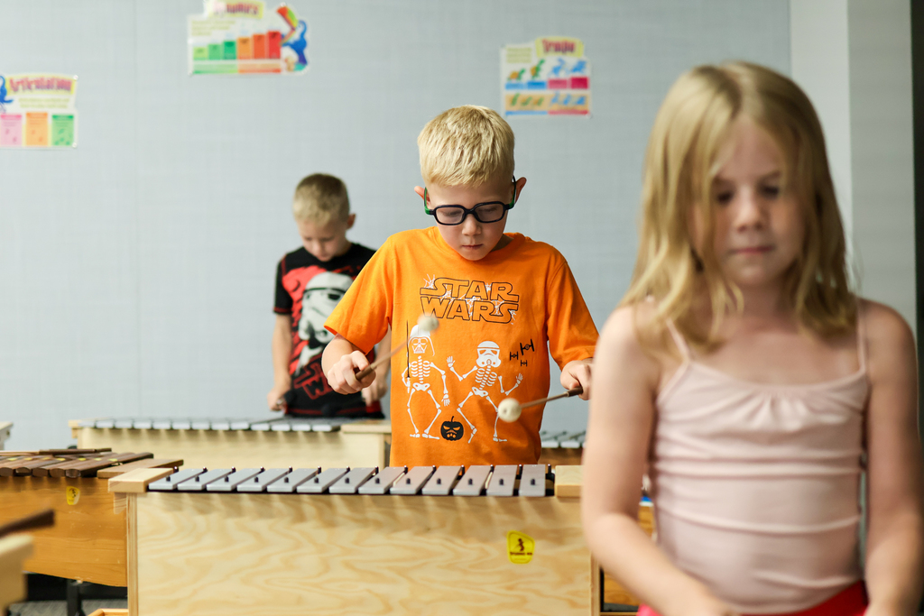 students play on musical instruments in a classroom