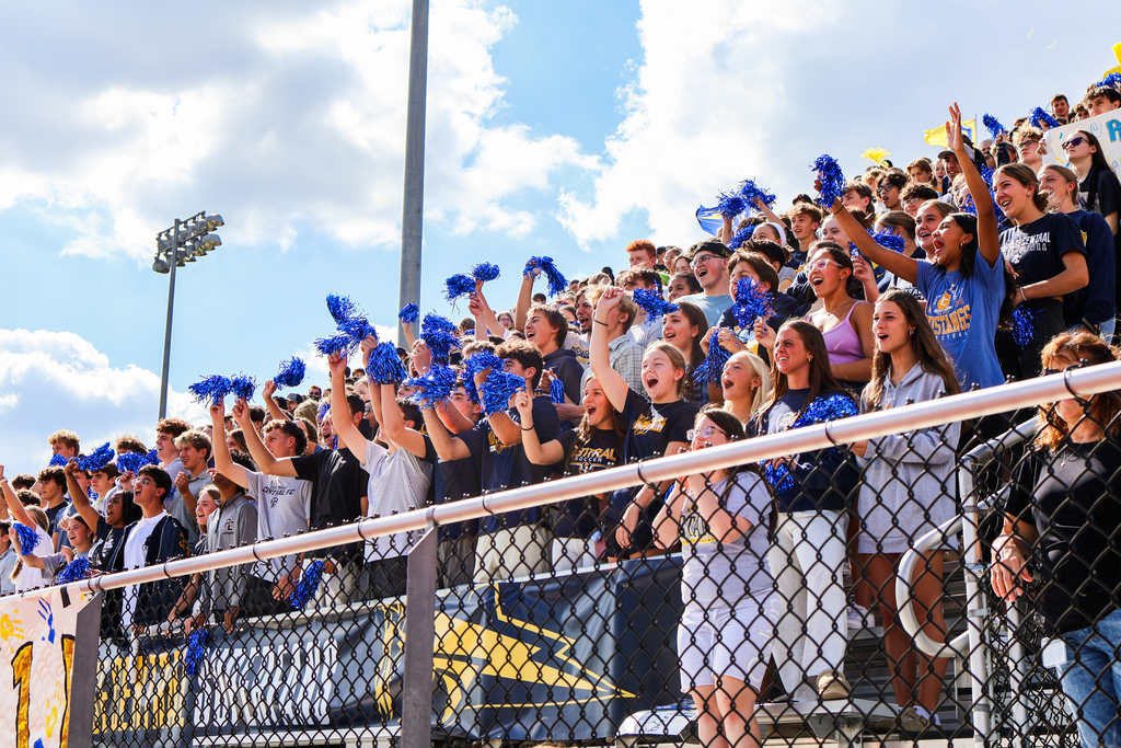 a crowd of students gathered in a football stadium cheering