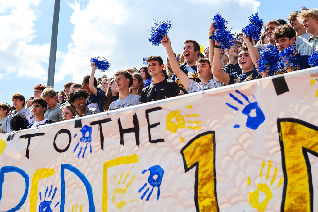 a crowd of students gathered in a football stadium cheering