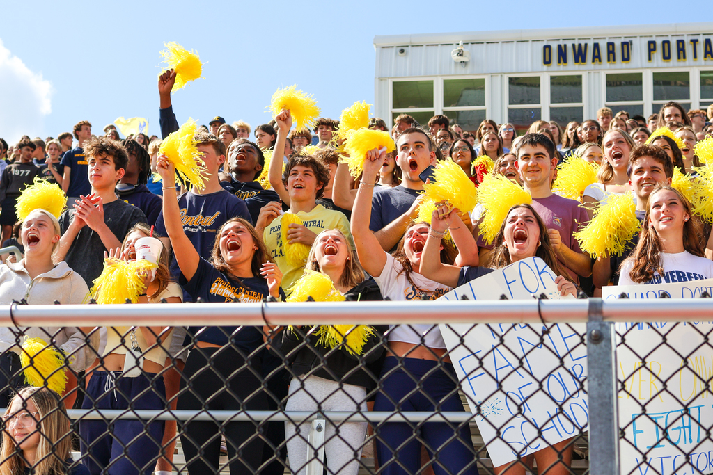 a crowd of students gathered in a football stadium cheering