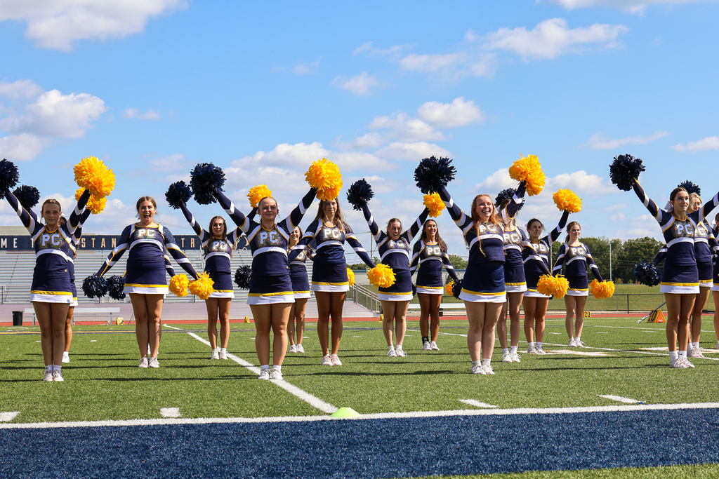 cheerleaders in a routine on a football field