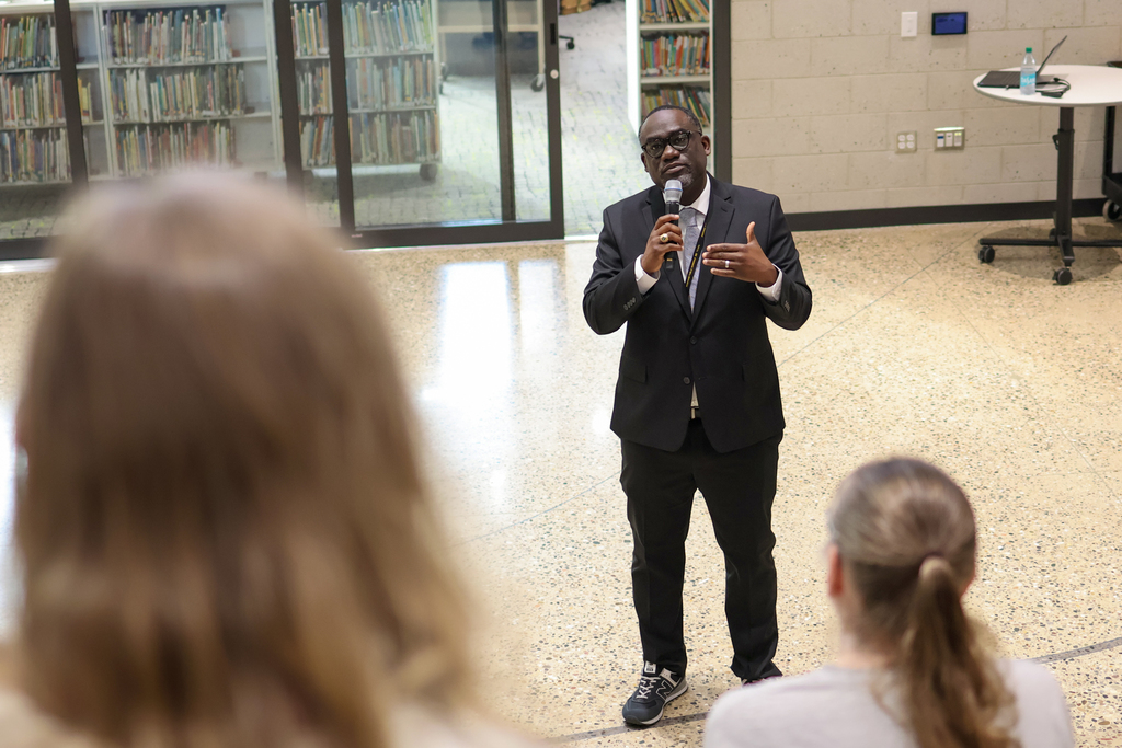 a man speaks to a crowd of people gathered on a large staircase