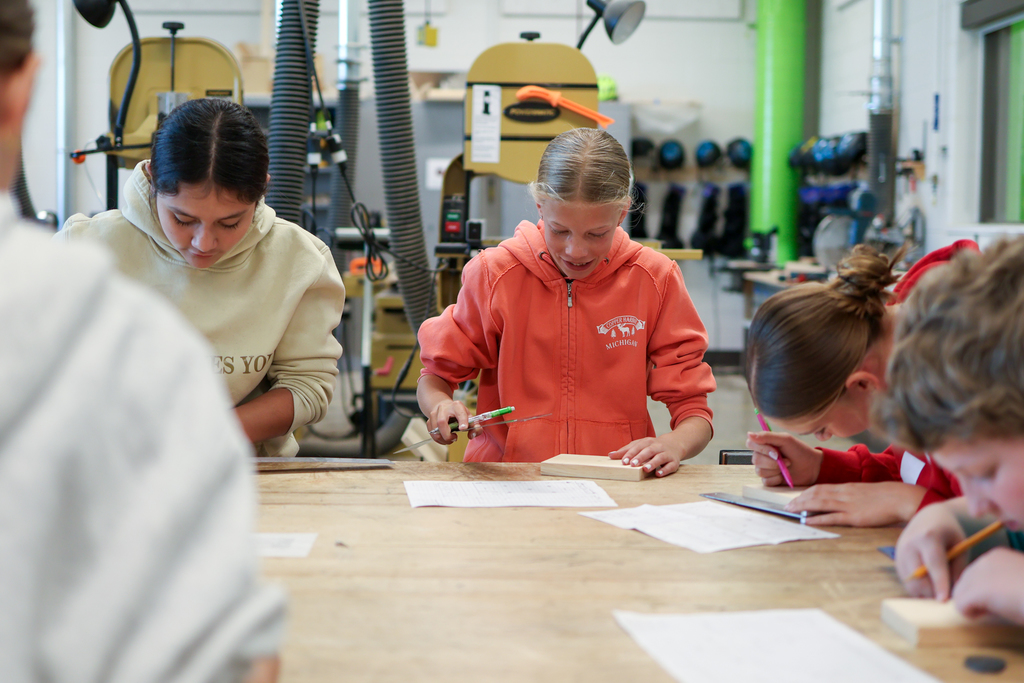 a group of students working at a table in a woodshop