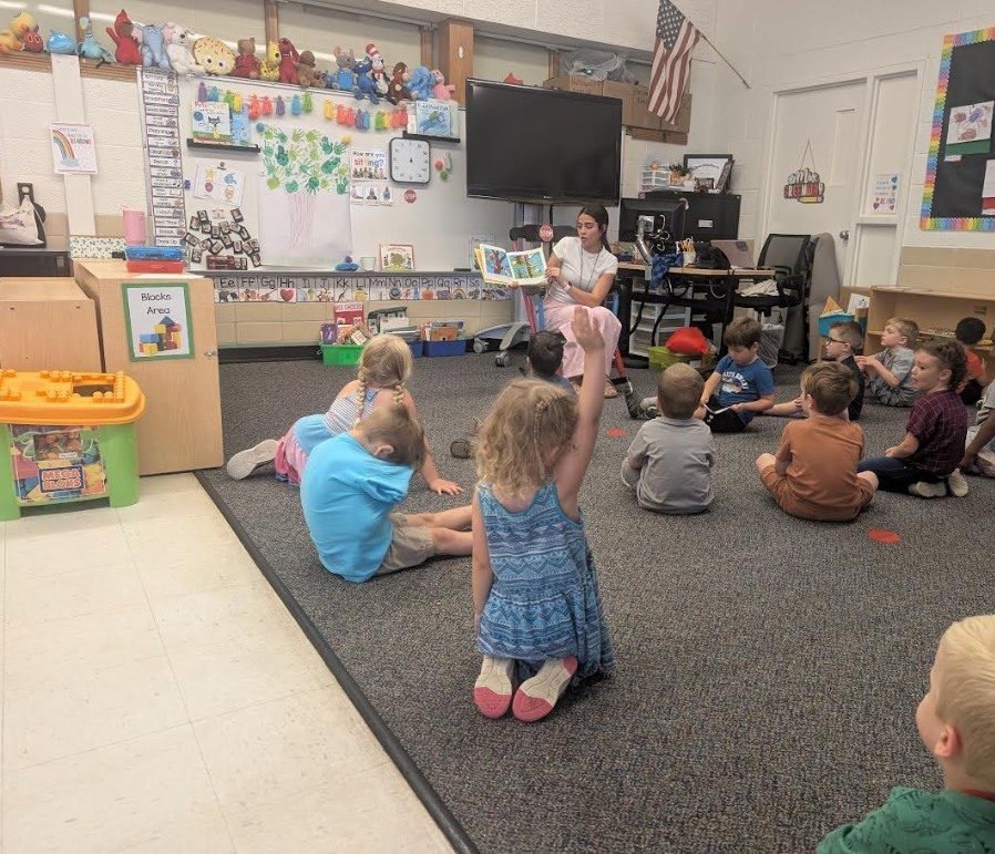 Students reading a book about Trees together.