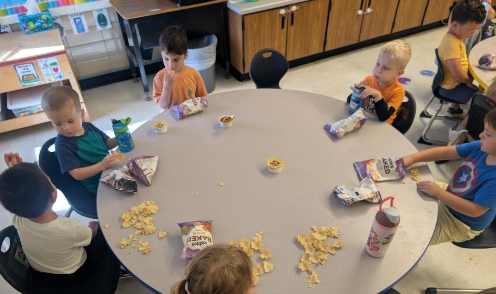 Students sitting together and eating snack.