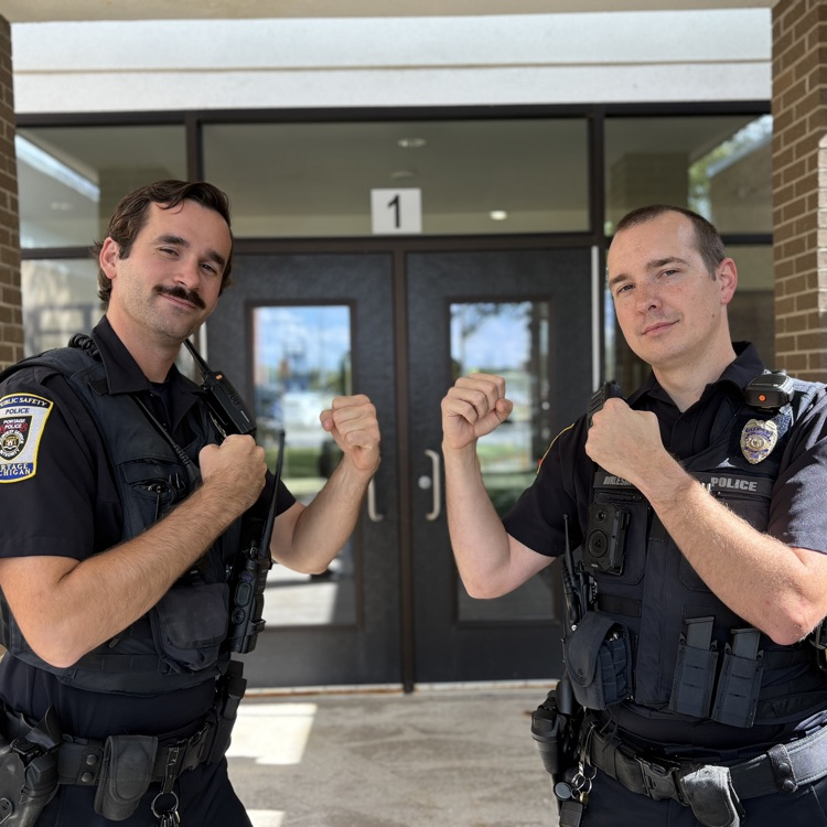 two police officers pose for a photo flexing their arms