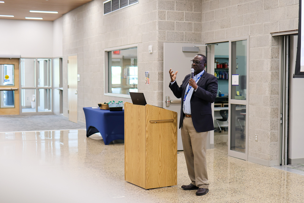 a man standing at a podium speaking into a microphone
