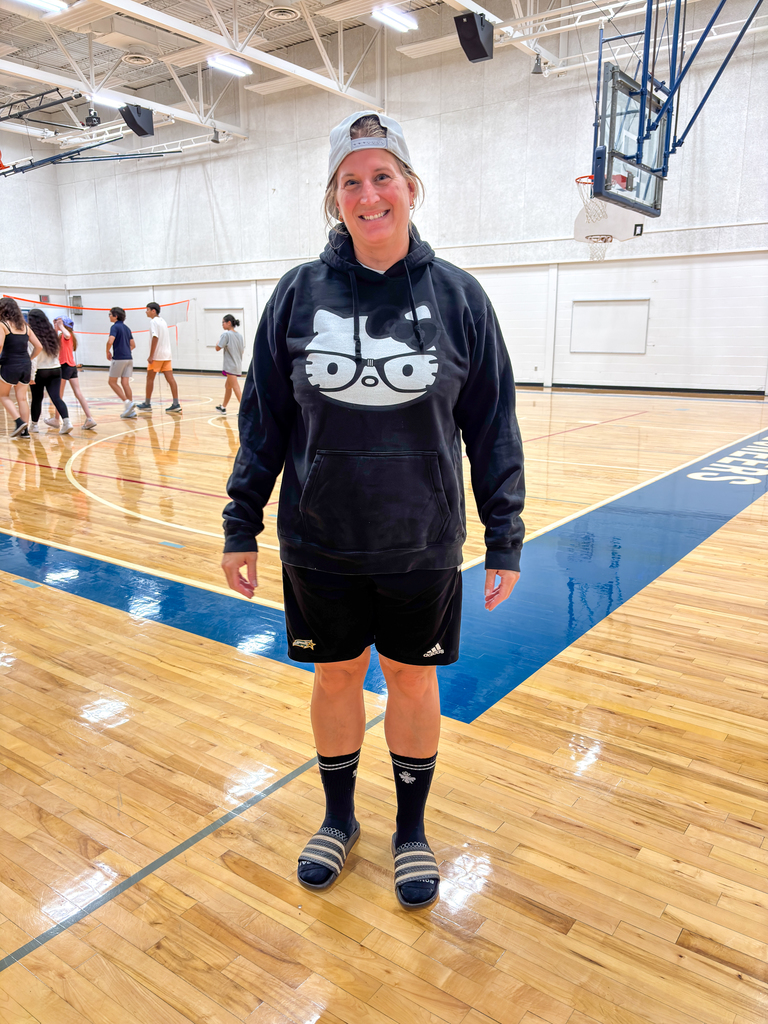 a woman wearing athletic clothes posing for a photo in a gym