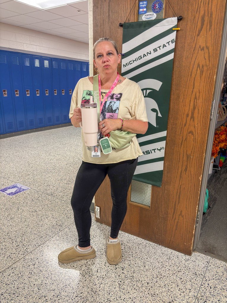a woman standing in a classroom doorway