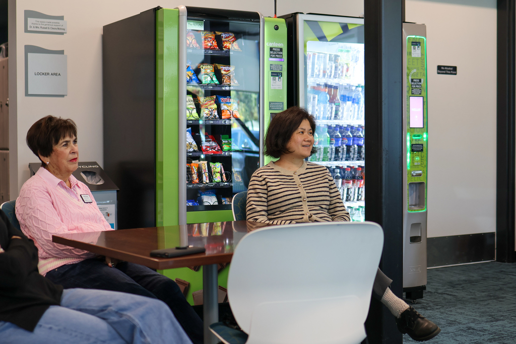 two women sitting at a table in a conference room