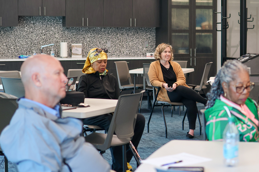 a woman smiles sitting surrounded by others