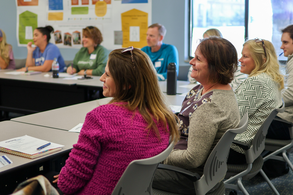 multiple people smiling at a conference room table