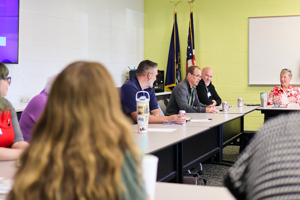 a man speaking at a table in a conference room