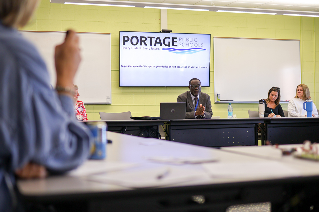 a man speaking at a table in a conference room