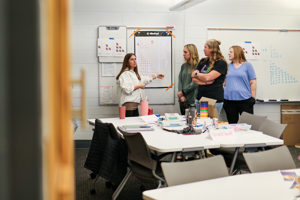 women standing near a whiteboard in a classroom