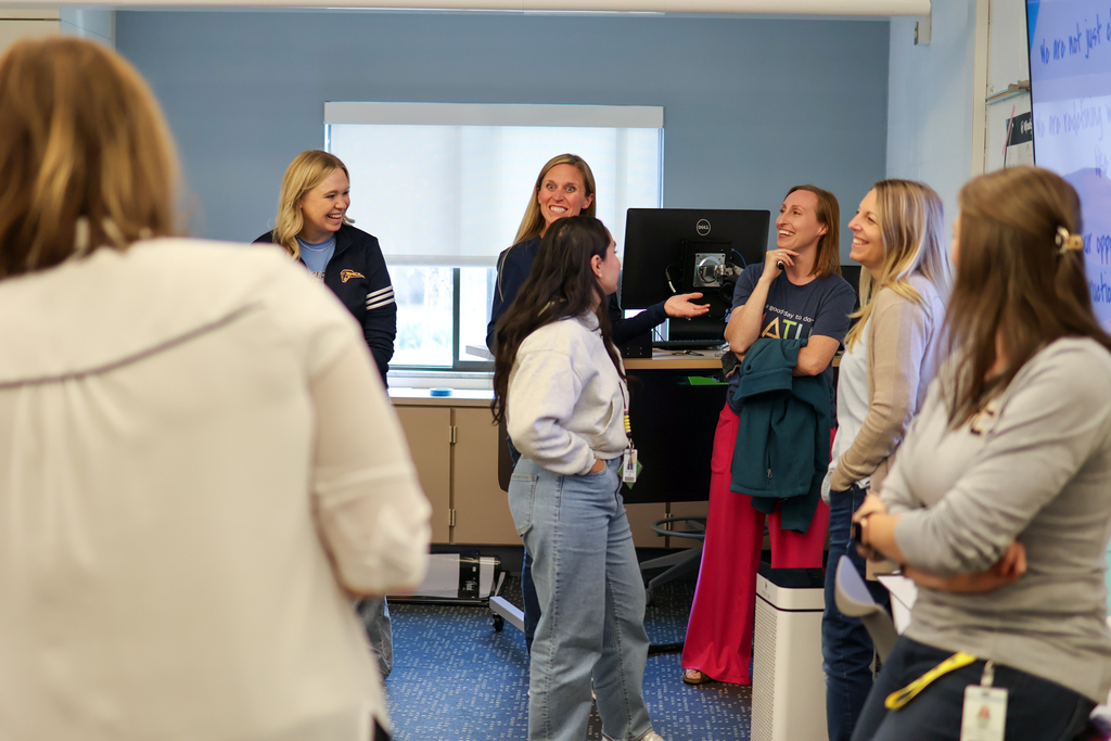 women laughing standing in a classroom