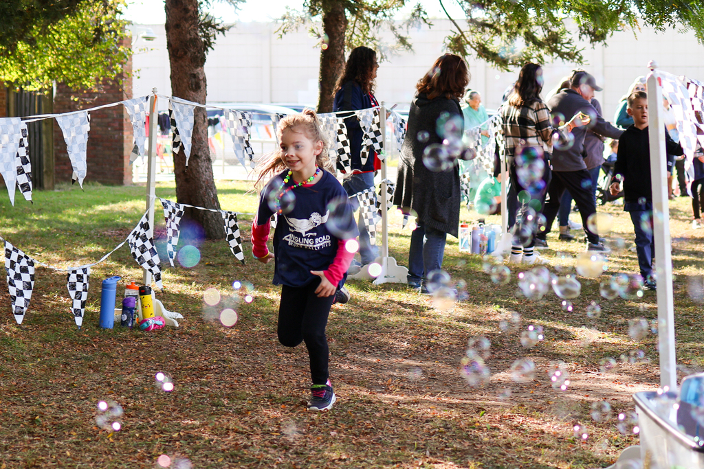 a girl running outside through bubbles