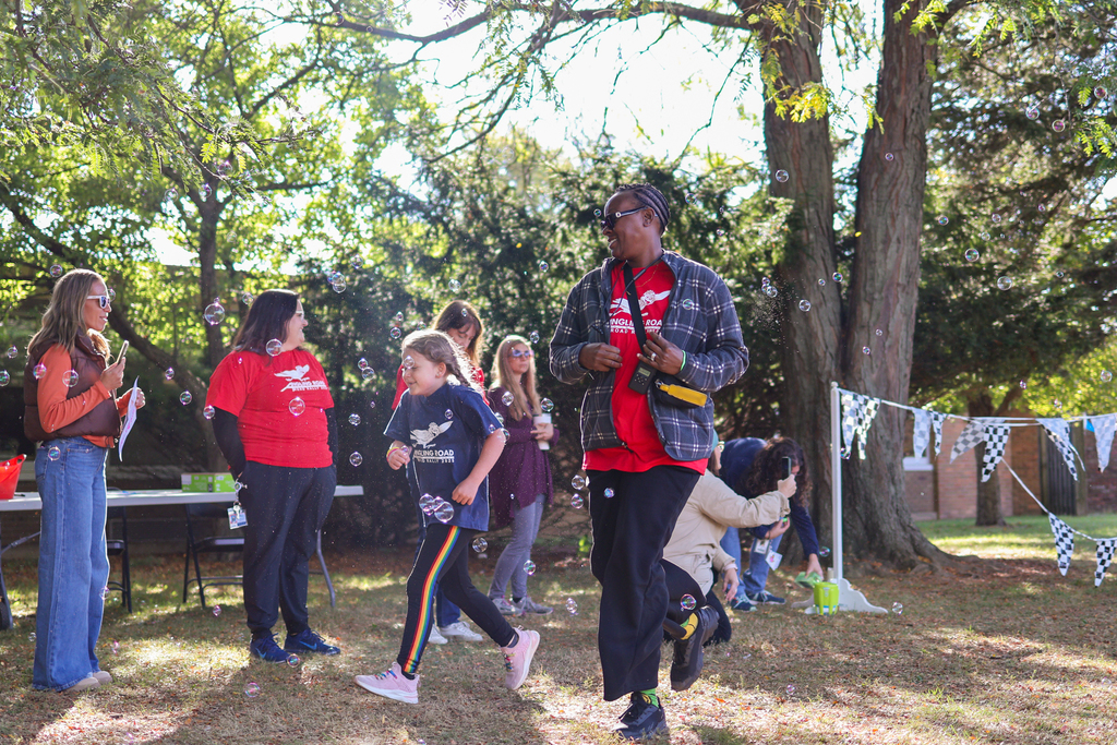 a woman and girl running outside through bubbles