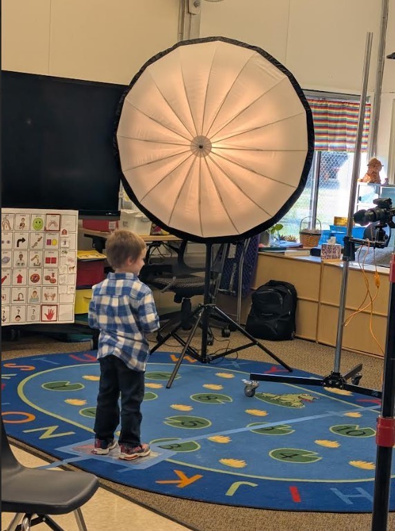 A four year old boy posing for a picture.
