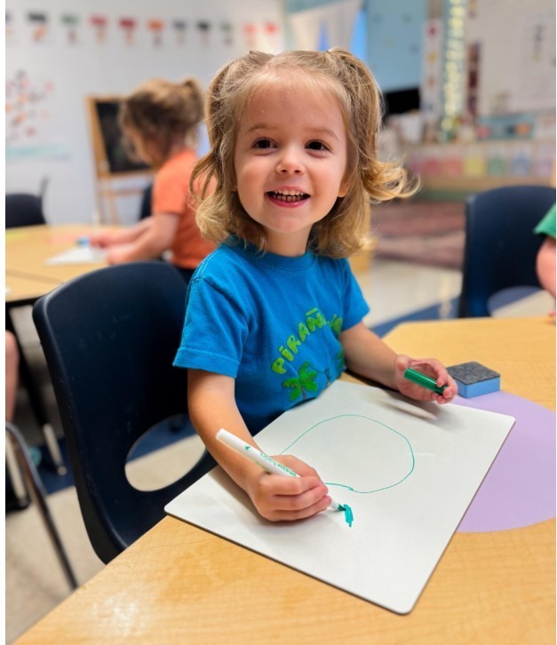 A boy at a table working on his handwriting.