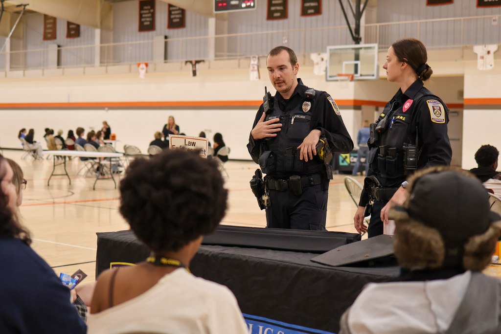 two police officers present to students inside a gym