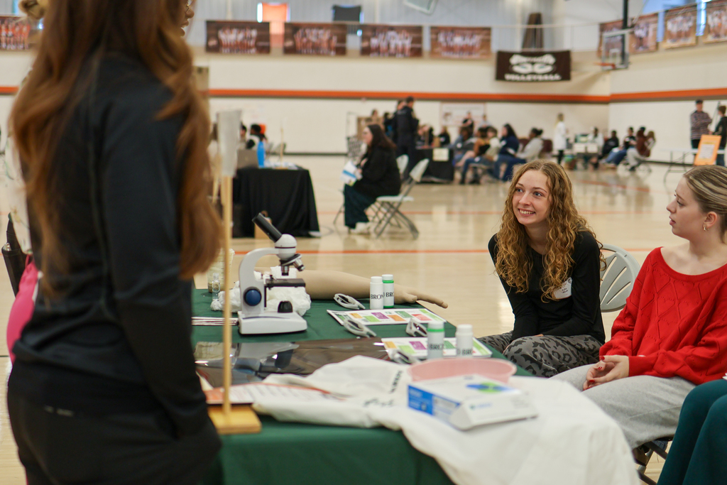 Students sitting and listening to a presentation inside a school gym